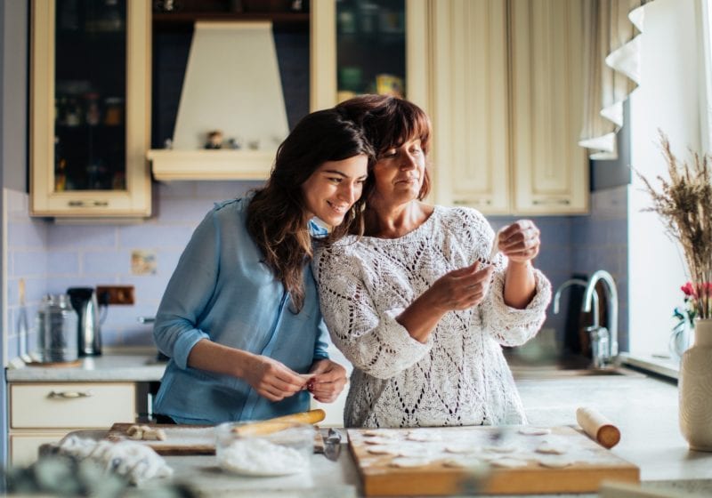 A mother and her daughter bake int he kitchen.