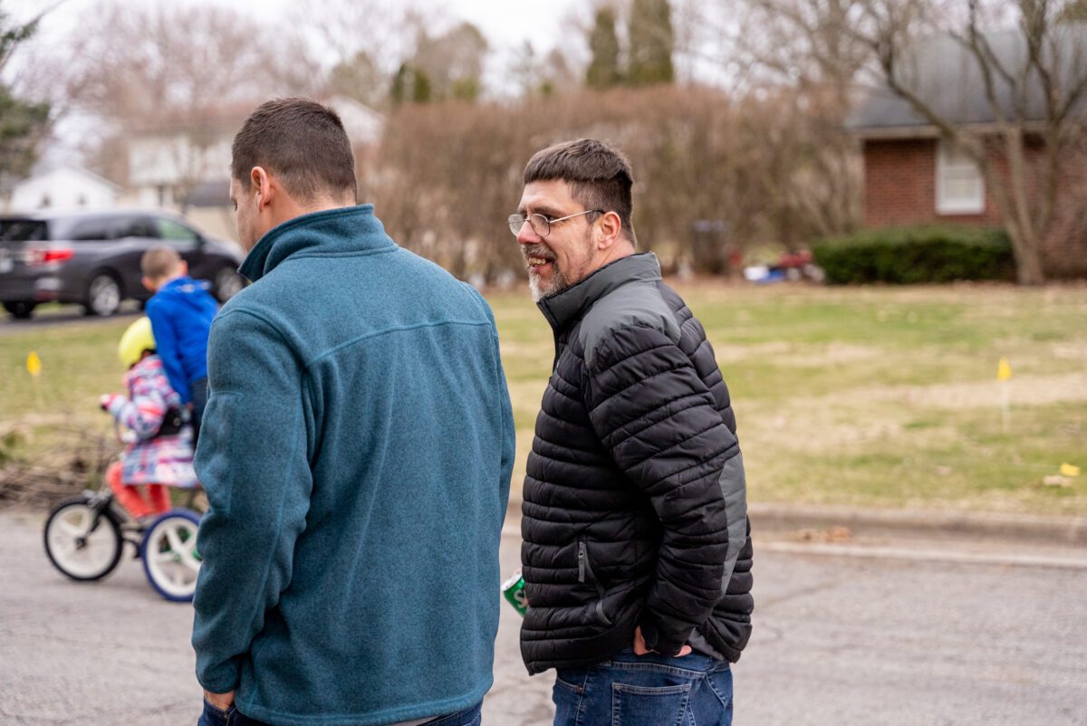 John and Ben Carmichael walking through a neighborhood
