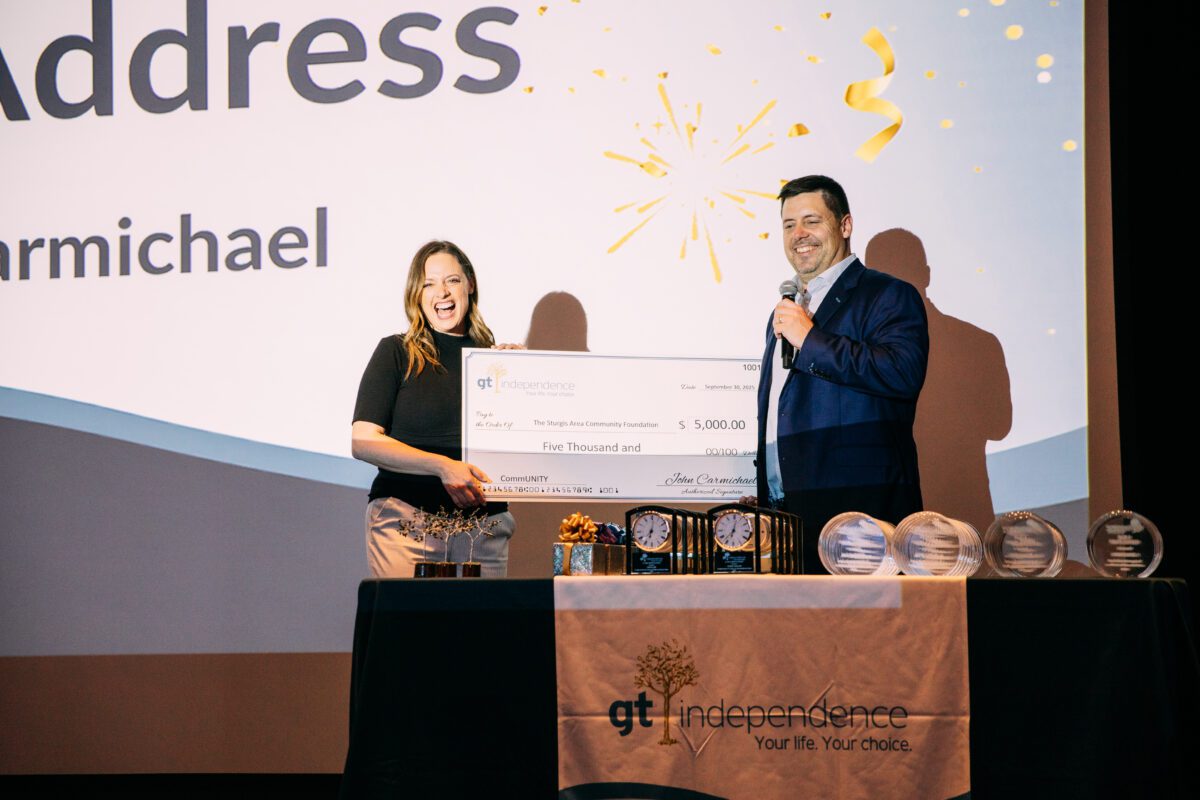 John Carmichael presents a donation check